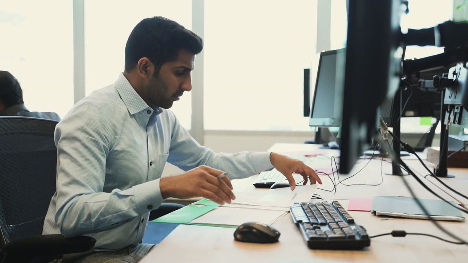 A Company Secretary reviewing a client's filing papers at his desk